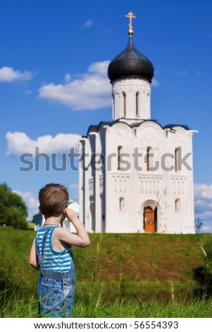 Little boy on a  orthodox church background. Church of the Intercession on the Nerl (Vladimir region of Russia)