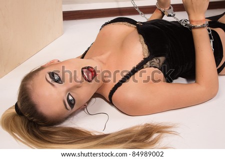 Crime scene simulation: pretty blonde in the handcuffs lying on the floor
