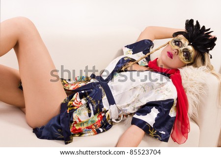 girl in mask and red scarf lying on sofa