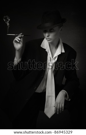 Vintage woman holding cigarette in mouthpiece in bar