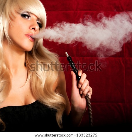 Beautiful Woman Smoking A Hookah And Smoke Issues From The Mouth