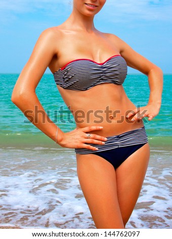 A girl with a beautiful slender figure against the sea