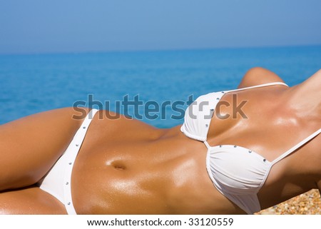 stock photo The young blonde girl with a beautiful body sunbathes on a 