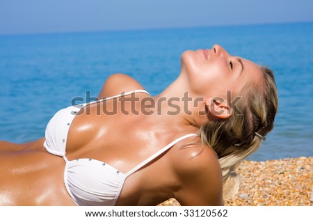 stock photo The young blonde girl with a beautiful body sunbathes on a 