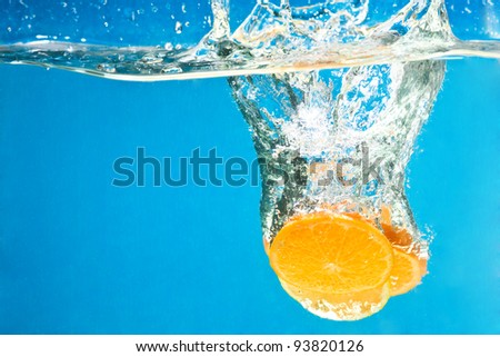 Orange splashing in water with blue background
