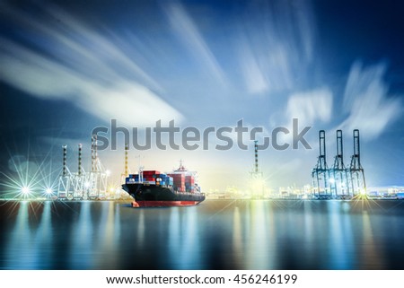 Logistics and transportation of International Container Cargo ship with ports crane bridge in harbor at Twilight sky for logistic import export background and transport industry.