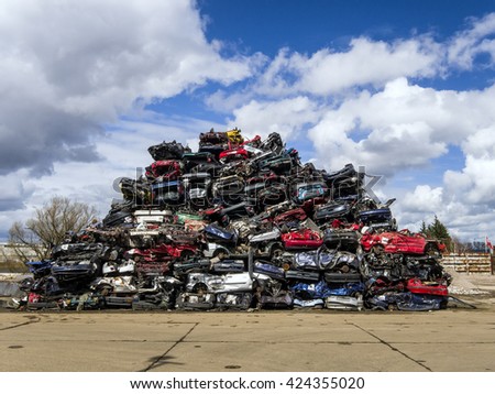 Neat pile of car wrecks ready to be processed as scrap metal