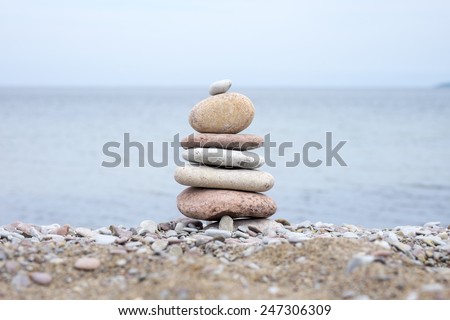 pile of smooth stones on the beach with the horizon out of focus