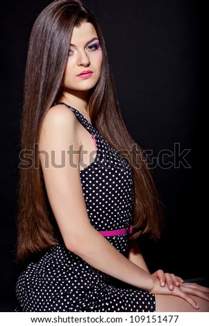 closeup portrait of a beautiful young woman with elegant long shiny hair from back , hairstyle , on a black background , healthy straight hair