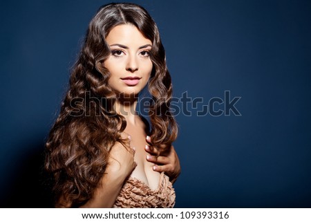 Portrait of young beautiful woman with long curly volume hair