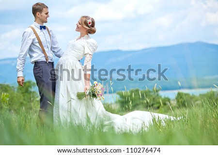 young wedding couple - freshly wed groom and bride posing outdoors on a lovely  day