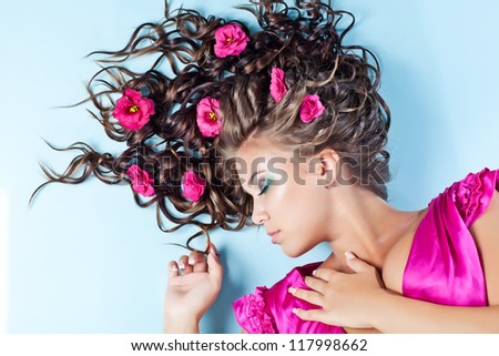 beautiful long-haired girl relaxing in her hair flowers