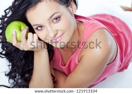 Head shot of woman holding apple against white background