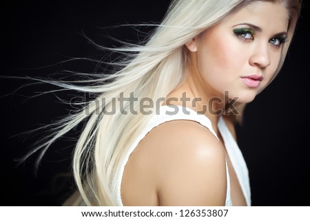 Beautiful Sexy Blond Girl. Long Hair. Blonde isolated on Black Background. Holiday Makeup.Make-up. Glamour Woman