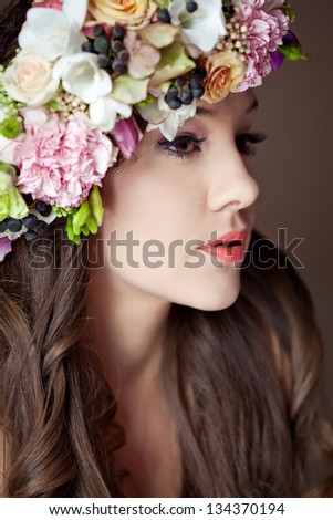 Studio portrait of young beautiful woman with flowers in hair