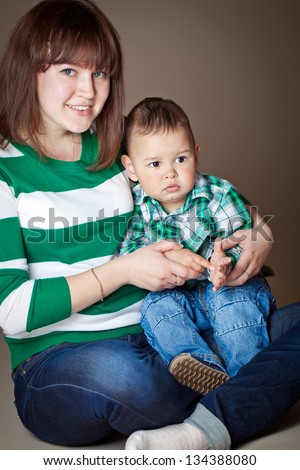 Portrait of nice boy with mother, little baby with mommy , pretty woman and cute cheerful child play game, happy smiling young lady hugging son, new family and love concept