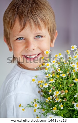 Smiling boy with a bouquet of red flowers