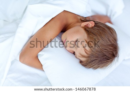 Portrait of a baby sleeping on a white pillow and blanket