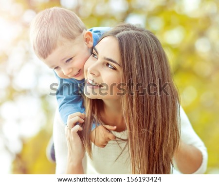 Happy Mother Playing With Her Son In The Park