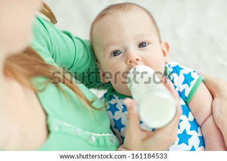 Young Mother Is Feeding Her Baby