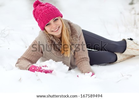 Winter woman in snow looking at camera outside on snowing cold winter day. Portrait  female model outside in first snow