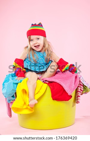 Child on a pile of dirty laundry. Children\'s clothing will never end.