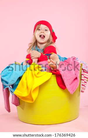 Child on a pile of dirty laundry. Children\'s clothing will never end.