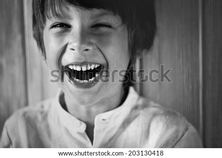 Black and white portrait of a happy cute little boy laughing