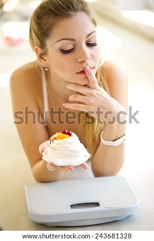Depressed woman with cake diet and weights