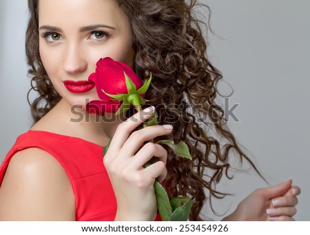Beautiful woman with a rose in his hands, smell fragrant roses