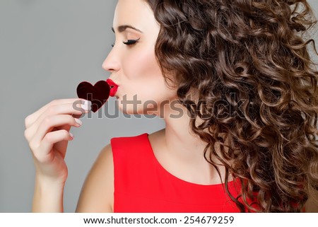 Love and valentines day woman holding heart smiling cute and adorable isolated on white background. Beautiful gorgeous woman with glamour bright makeup and red heart. Valentine\'s Day.