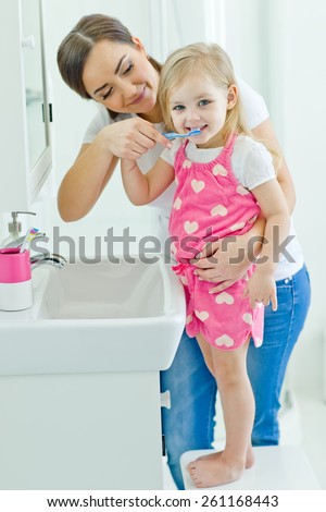 happy family and health. mother and daughter baby girl brushing their teeth together
