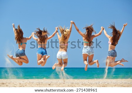 summer, vacation, holiday, happy people concept - a group of friends jumping and running on the beach