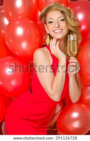 Beautiful woman with a glass of champagne. Holiday balloons.