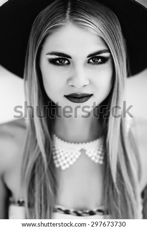 Beautiful young model in hat on the white background. Black and white photo