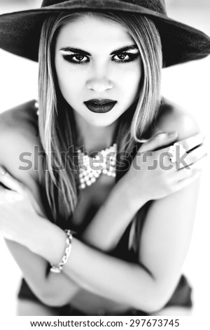 Beautiful young model in hat on the white background. Black and white photo
