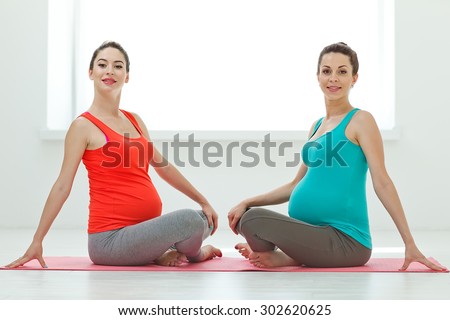 Prenatal exercise. Beautiful pregnant woman performing yoga