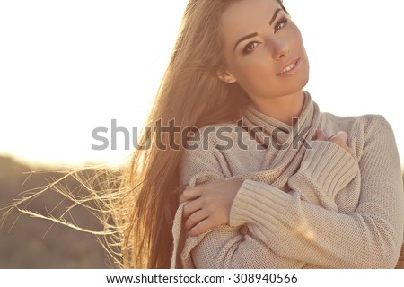 Beautiful woman in a sweater in the fall.Warm light sunset