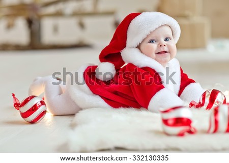 Beautiful little baby celebrates Christmas. New Year\'s holidays. Baby in a Christmas costume with gift