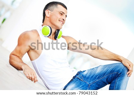 The young man in the earphones, lying on the floor listening to music