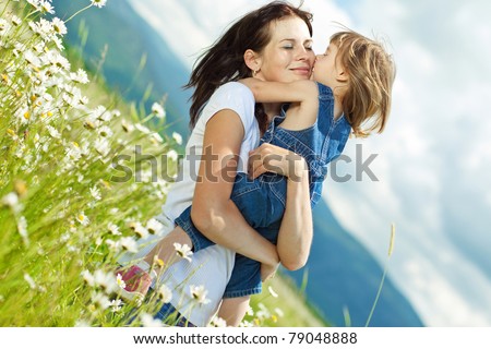 Smiling mother and little daughter on nature. Happy people outdoors