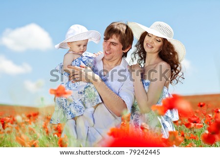 Family resting in a field of flowers. Man, woman and child in nature.