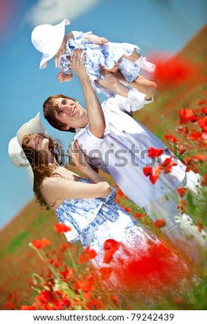 Family resting in a field of flowers. Man, woman and child in nature.