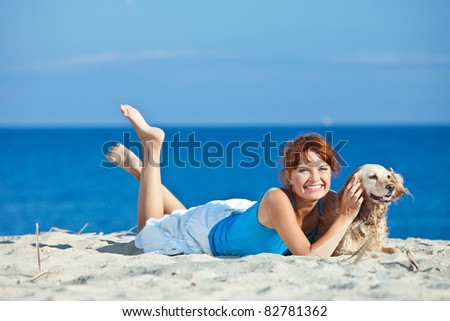 A beautiful woman with a playful young dog on nature