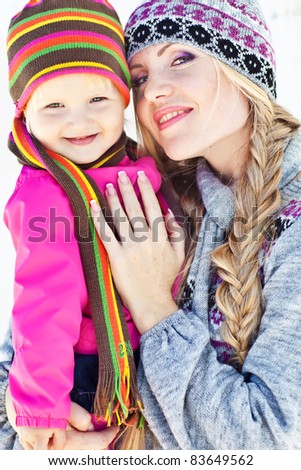 Happy young mother and daughter in winter clothing to have fun