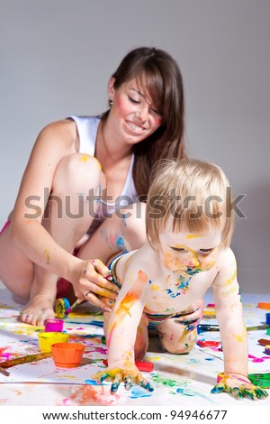happy young mother and son painting