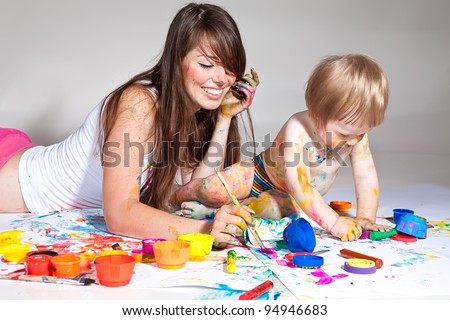happy young mother and son painting