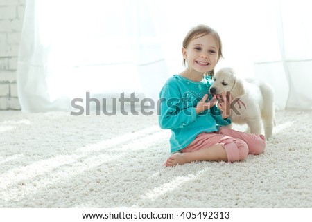 The child with the dog lying on the mat at home
