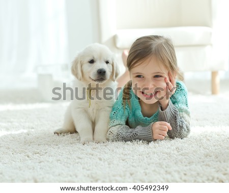 The child with the dog lying on the mat at home