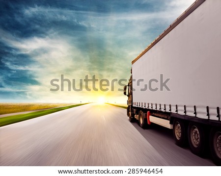 Truck driving towards sunset